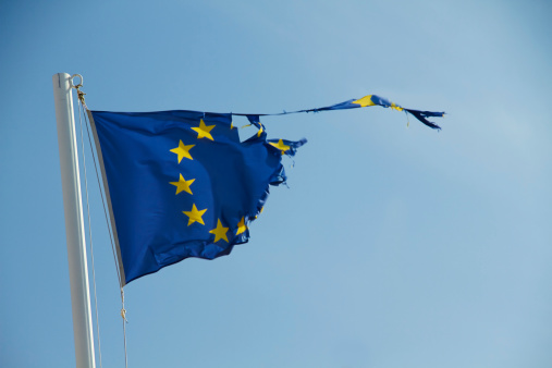 Detail of the national flag of Greece waving in the wind with blurred european union flag in the background on a clear day. Democracy and politics. European country. Selective focus.
