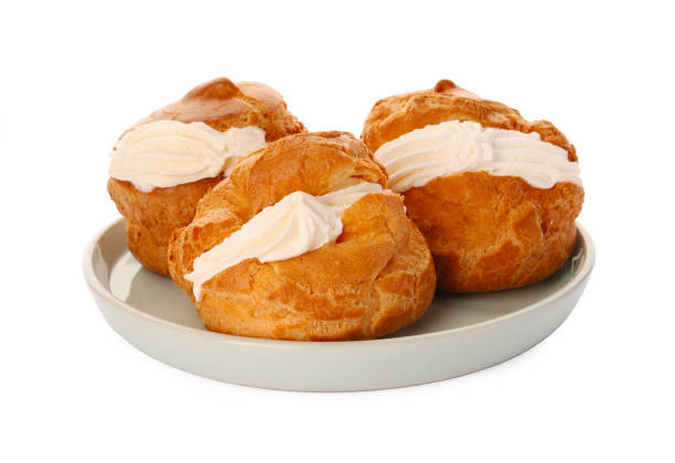 istock Delicious profiteroles with cream filling on white background 1808066912