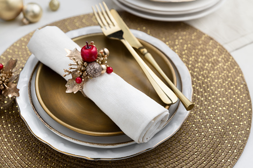 Christmas place setting table decoration, gold and red festive centerpiece arrangement on plate close up