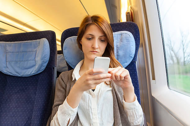 istock Young woman checking her smart phone on train 180806871