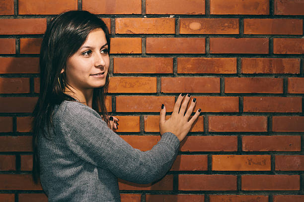 Portrait of young cute brunette girl background brick wall.