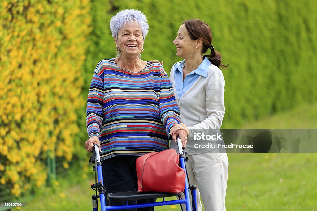 Senior woman with walker and caregiver Females Stock Photo