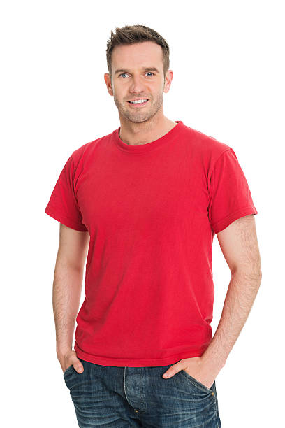 Casual Man in Red T Shirt Portrait of confident man standing with hands in pockets against white background three quarter length stock pictures, royalty-free photos & images