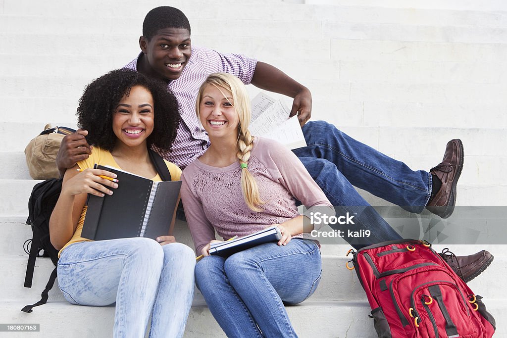 Students studying outdoors Group of multi-ethnic students studying on steps of school building. Backpack Stock Photo