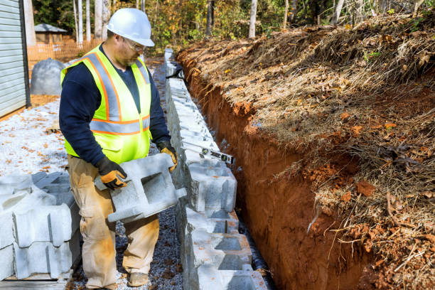 istock Construction of retaining walls, which is being performed by a contractor installing concrete block walls 1808073300