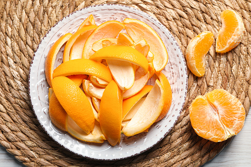 Orange peels preparing for drying and fresh fruit on white wooden table, top view