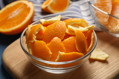 Orange peels preparing for drying and fresh fruits on table, closeup