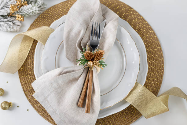 Plates and cutlery arranged on table for Christmas dinner overhead view