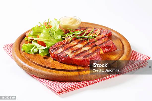 Grilled Pork Neck On A Round Cutting Board Stock Photo - Download Image Now - Appetizer, Arugula, Bacon