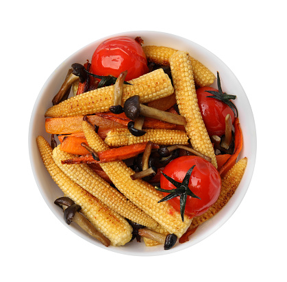 Tasty roasted baby corn with tomatoes and mushrooms isolated on white, top view