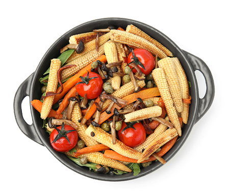 Tasty roasted baby corn with tomatoes, capers and mushrooms isolated on white, top view