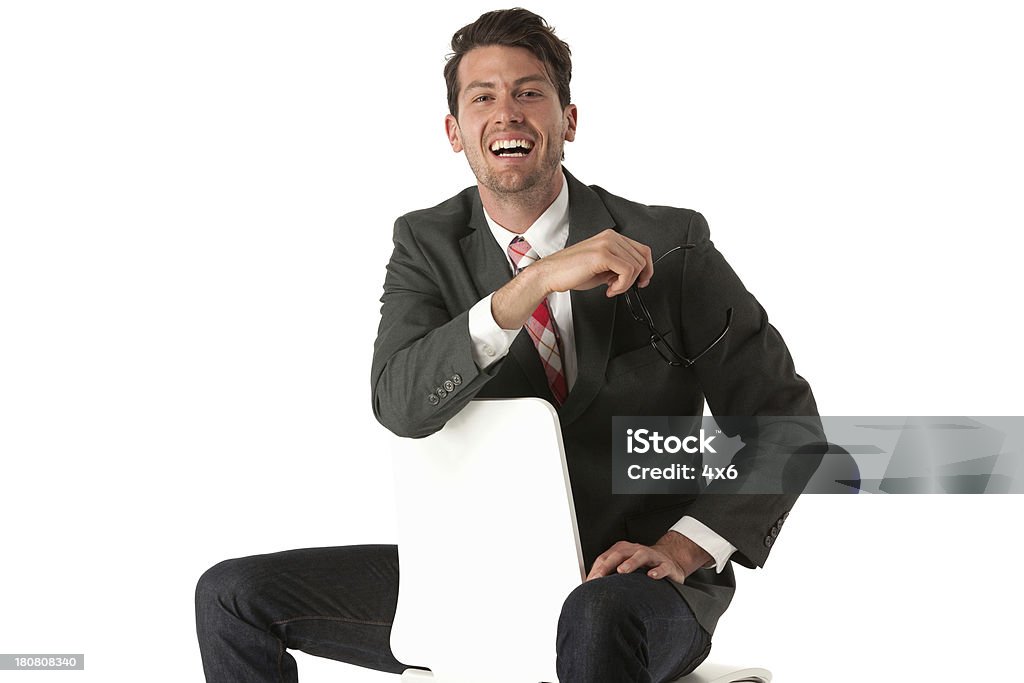 Feliz hombre de negocios sentado en una silla y regresiva - Foto de stock de 20 a 29 años libre de derechos