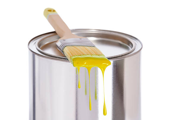 istock Yellow dripping paint brush on a tin of paint 180808897