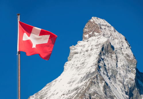 Summit of  Matterhorn as seen from Zermatt and the Flag of Swiss Confederation.