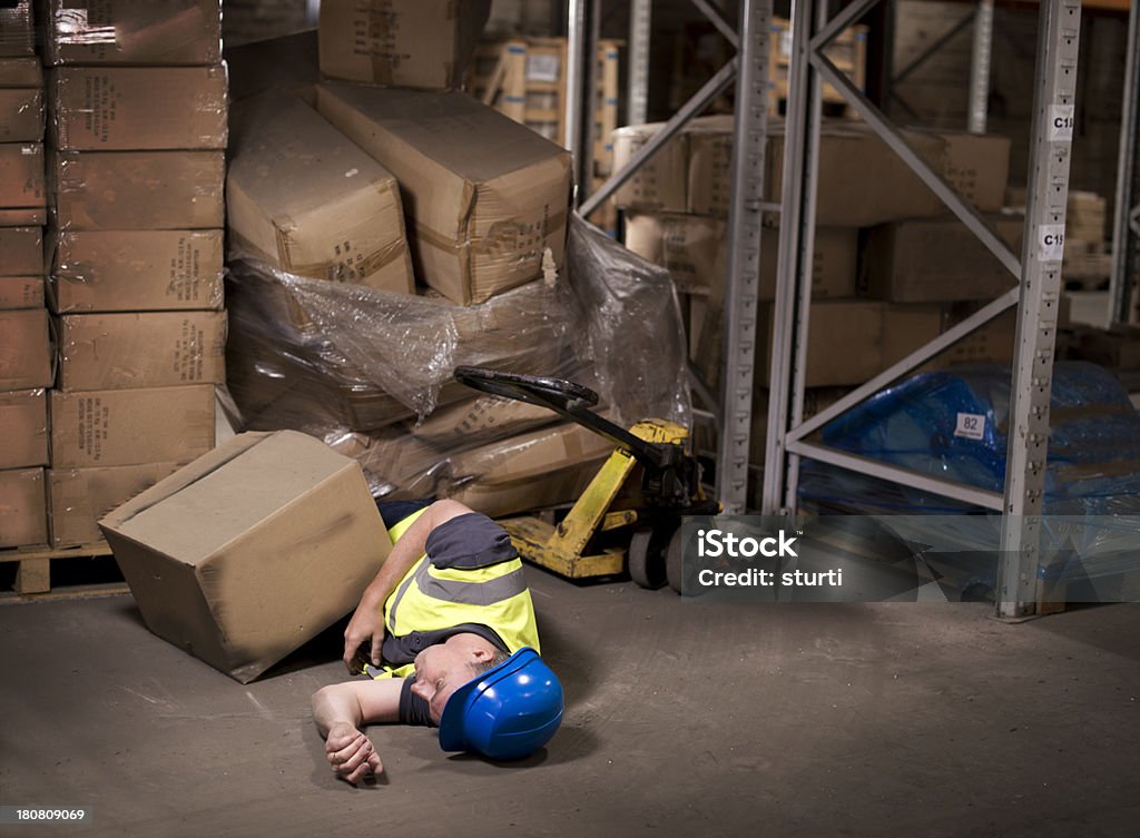 industrial injury warehouse worker tries to move poorly stacked pallet Misfortune Stock Photo