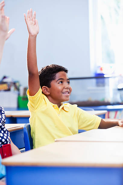 istock Little boy in school raising hand 180809264