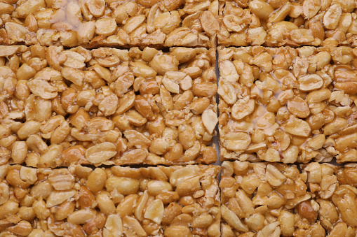 Delicious peanut bars (kozinaki) as background, top view