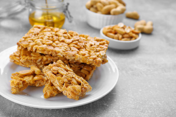 istock Delicious peanut kozinaki bars on light gray textured table, closeup. Space for text 1808094182