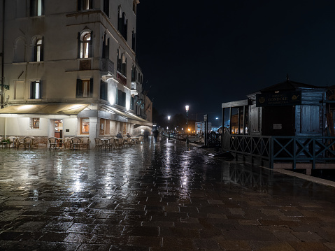 Venice, Italy - November 2 2023: Fondamenta del Monastero street, on the shore of Canal Grande, on a rainy night. Venice is the capital of the Veneto region.