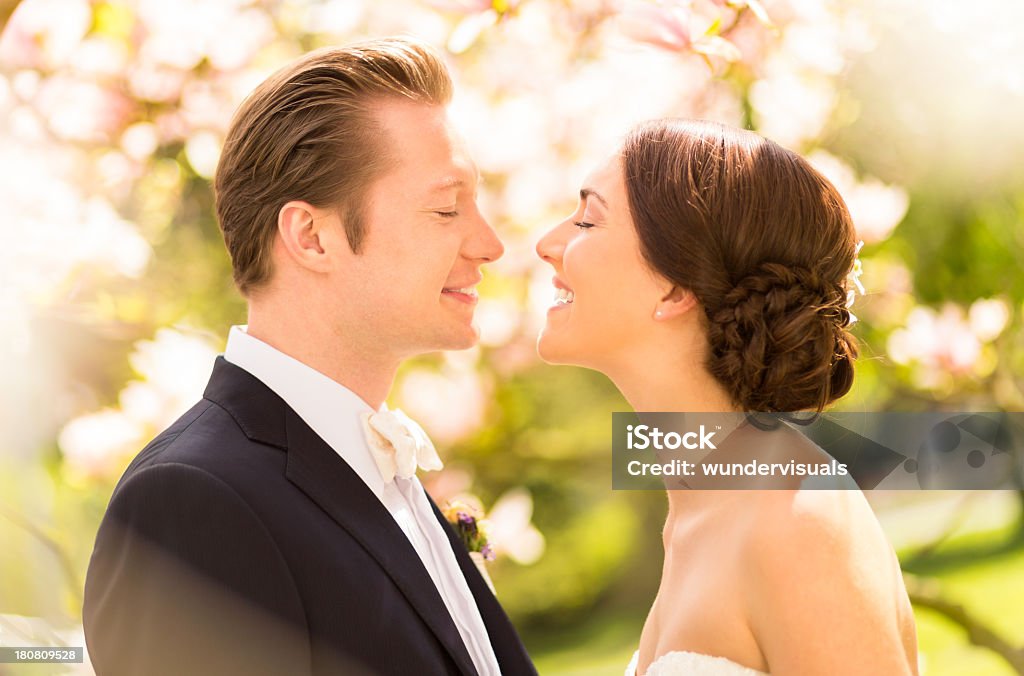 Bride and groom kissing under Магнолия цветы - Стоковые фото Just Married - английское словосочетание роялти-фри