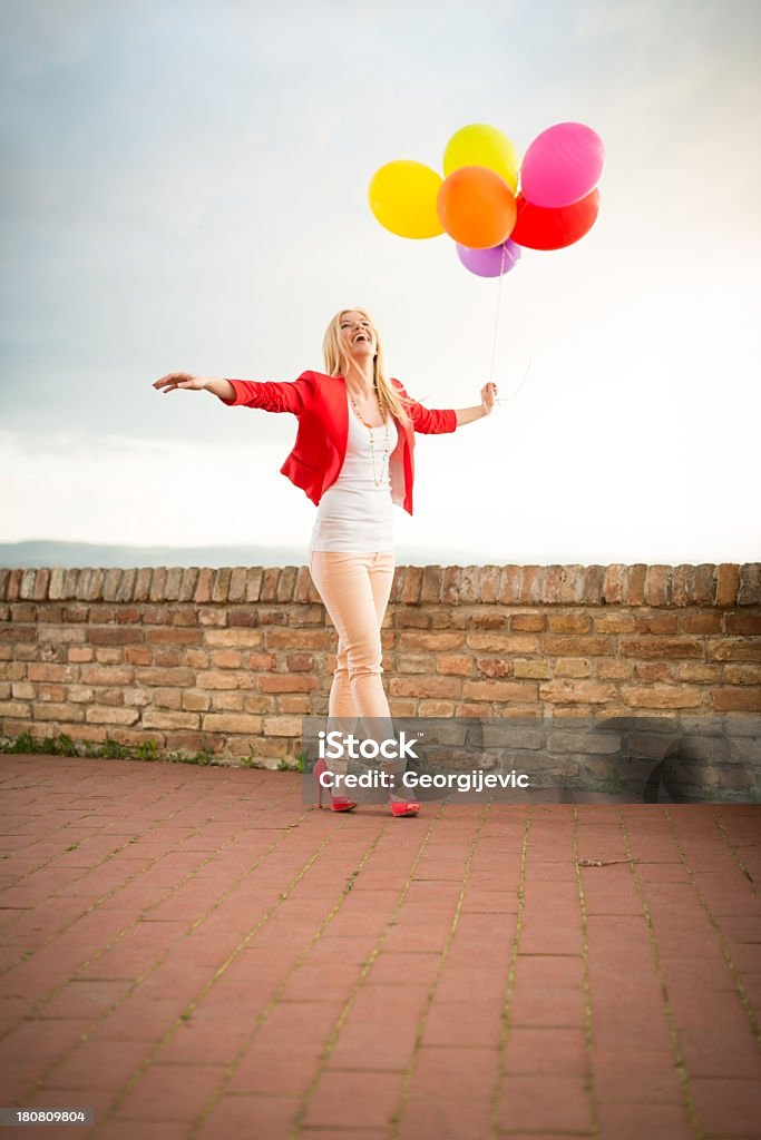 Молодые, улыбается женщина с воздушными шарами - Стоковые фото Вертикальный роялти-фри
