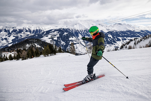 Teenage boy skiing on ski slope in European Alps, Austria. \nSunny winter day.\nCanon R5