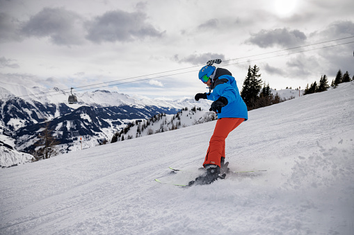 Teenage boy skiing on ski slope in European Alps, Austria. 
Sunny winter day.
Canon R5