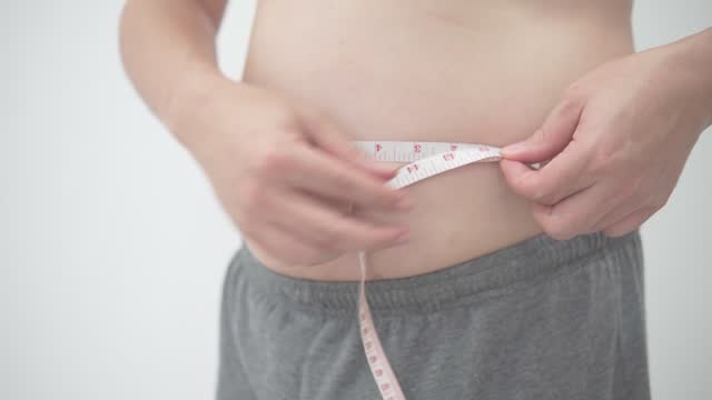 Health Conscious Individual Measuring Waist Size - slow motion.