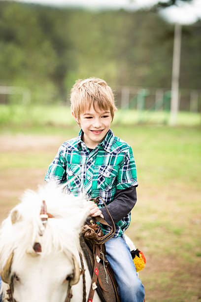 istock Little boy riding a horse 180810675