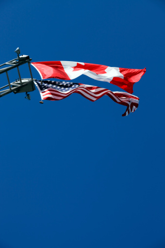 Canadian and American flags flying side by side.