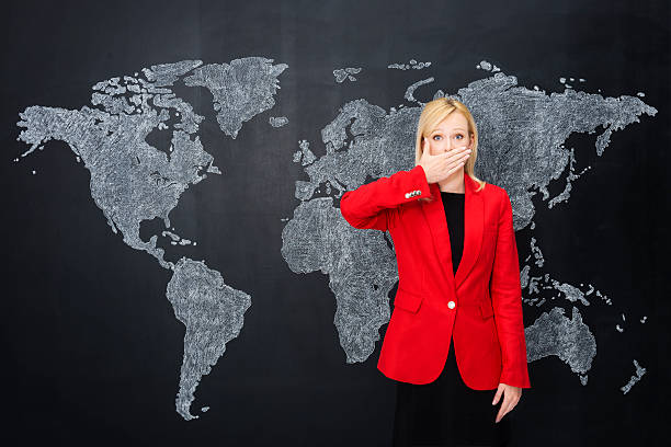 istock Businesswoman by world map with hand on mouth 180810968