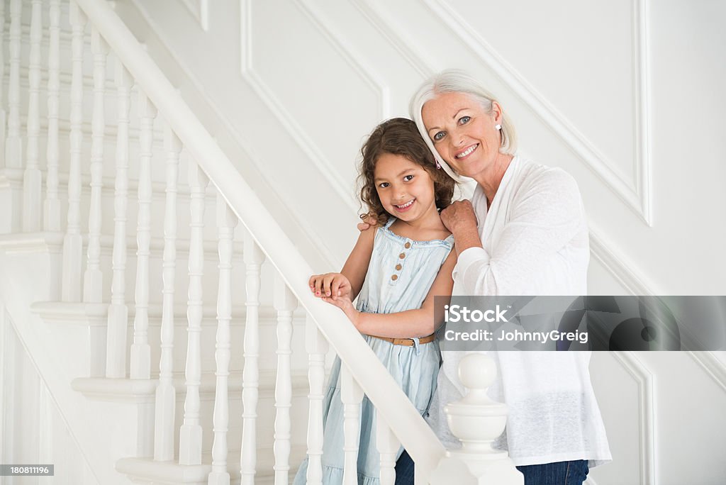 Granddaughter y abuela de pie juntos en las escaleras. - Foto de stock de 4-5 años libre de derechos