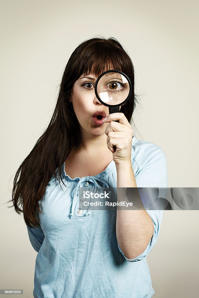 Ahora, fíjese en ello. Mujer joven con lupa - Foto de stock de Lupa - Instrumento óptico libre de derechos