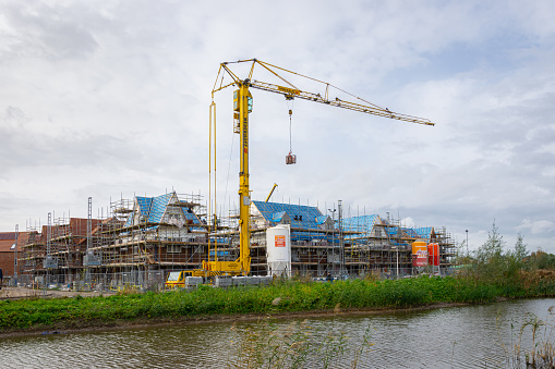 Waddinxveen, Netherlands - November 8, 2023: Lifting crane in new housing estate under construction. Location is 