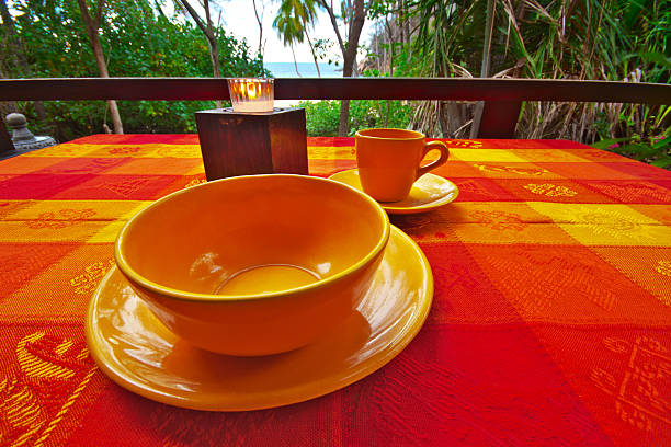 Tropical Table Setting on Majahuitas Beach "An early morning table stting overlooking the palm trees of Majahuitas Beach and across the Bay of Banderas to Puerto Vallarta, Mexico.All images in this series..." majahuitas beach stock pictures, royalty-free photos & images
