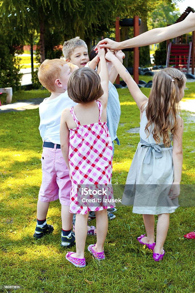 Kids Playing in Garden Five preschool kids playing in the playground. Child Stock Photo