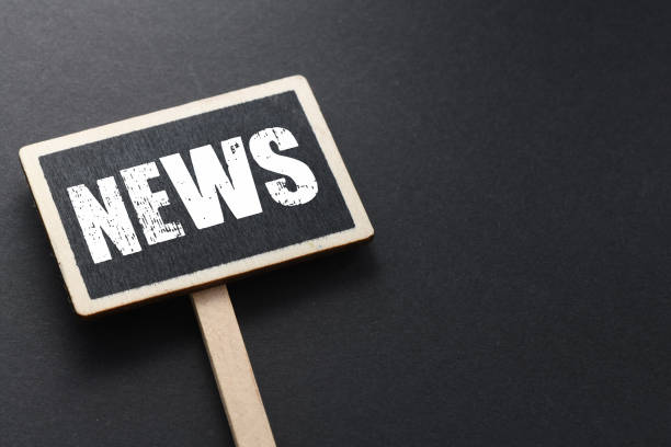 istock NEWS word on a small chalkboard and black empty background. 1808119285