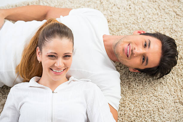 jovem casal deitado no tapete - couple loving lying on back carpet imagens e fotografias de stock