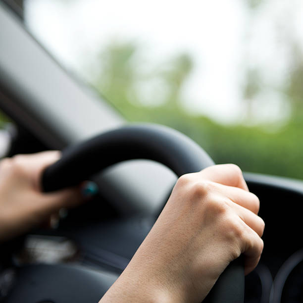 istock Close-up of hands on steering wheel 180812707