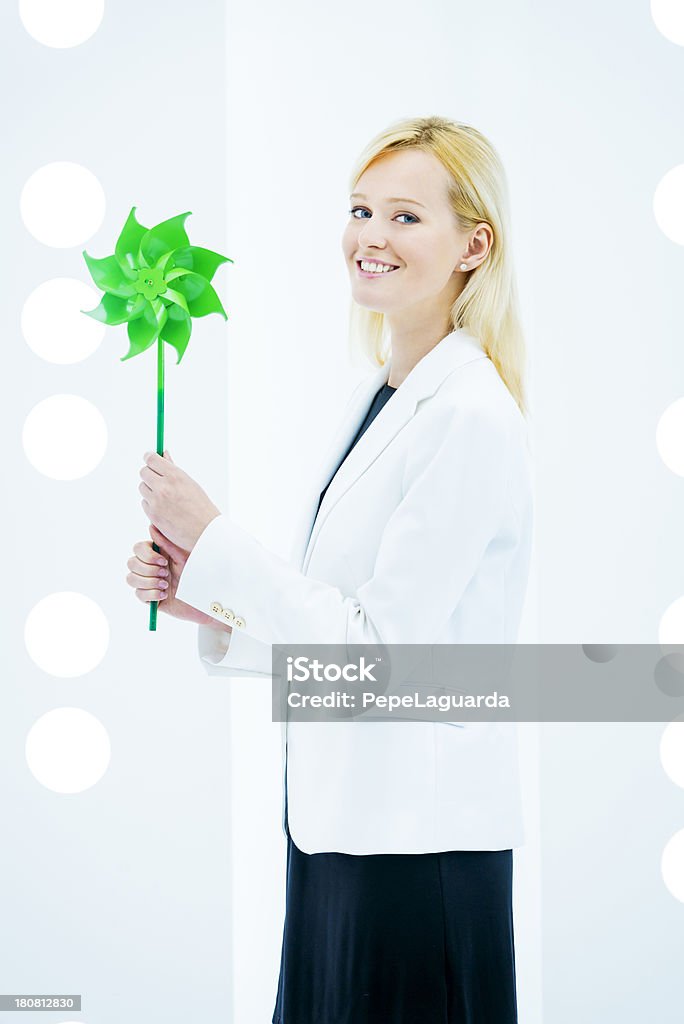 Responsible green business Green business: businesswoman holding a green pinwheel in a contemporary design office. 20-29 Years Stock Photo