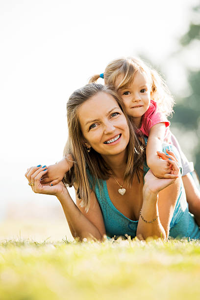 istock Mother and daughter lying in the park. 180812865