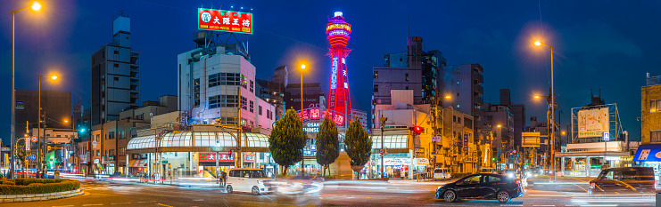 The iconic spire of the Tsutenkaku Tower overlooking Shinsekai and busy highways illuminated at night in the heart of Osaka, Japan’s vibrant second city.