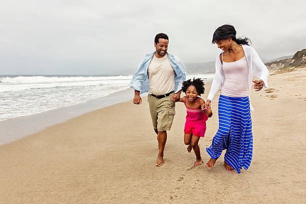 Family of Three Walking on The Beach