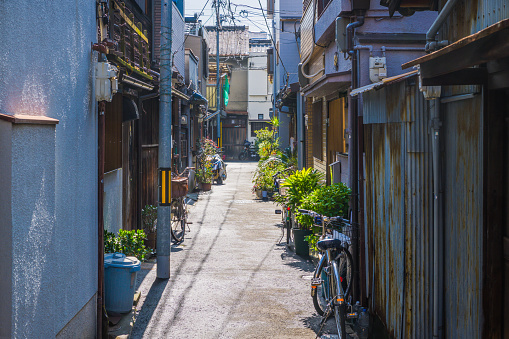 Quiet alleyway bordered by urban homes in downtown Osaka, Japan.
