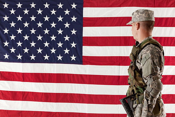 istock Side view of an army man looking at American flag 180814603
