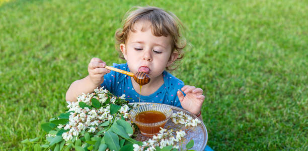 The child eats honey in the garden. Selective focus.