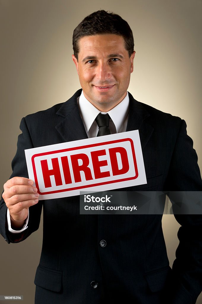 Businessman holding hired sign. Businessman holding hired sign. Studio shot Human Resources Stock Photo
