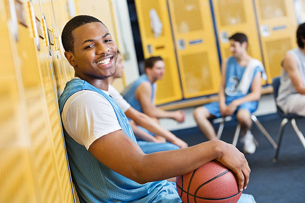 szczęśliwy nastoletnie koszykarz w szkole średniej przebieralnia - team sport enjoyment horizontal looking at camera zdjęcia i obrazy z banku zdjęć