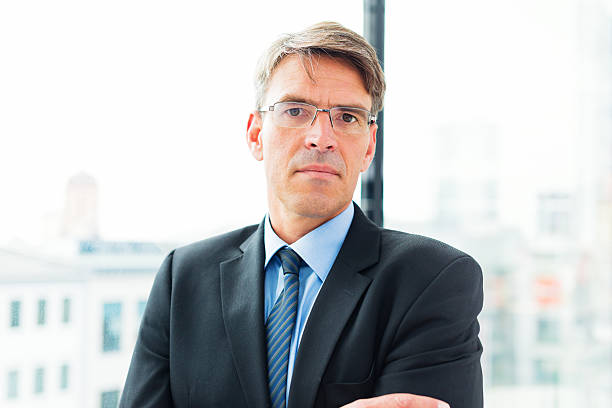 istock businessman standing by the window 180815639