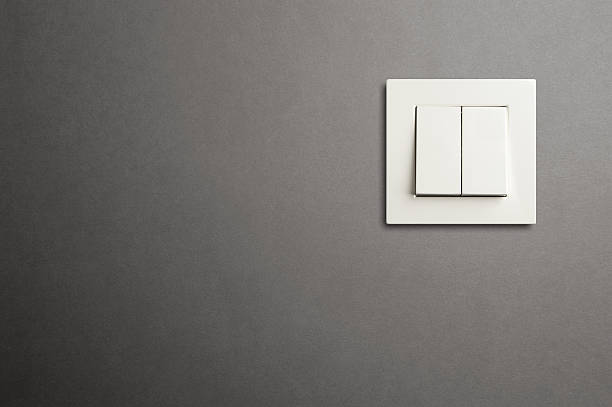 Electric switch in on gray wall Electric switch in on gray wall. Close-up light switch stock pictures, royalty-free photos & images